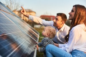 年轻的父母带着孩子在家里看太阳能电池板