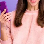 一个女人在紫色的背景前使用电话