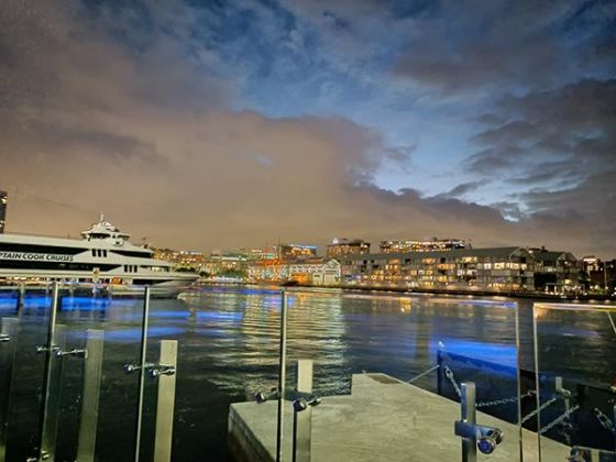 夜间拍摄的船在水上与城市的背景