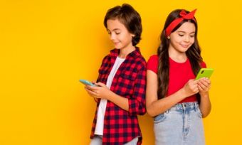 最好的手机对孩子articl形象和女孩和男孩看着手机在黄色的背景下