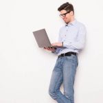 戴眼镜的年轻人正在使用笔记本电脑