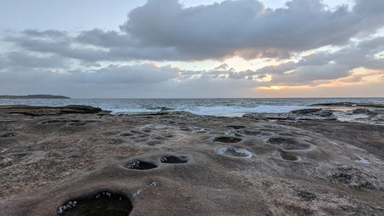 日出时的海洋和岩石水池