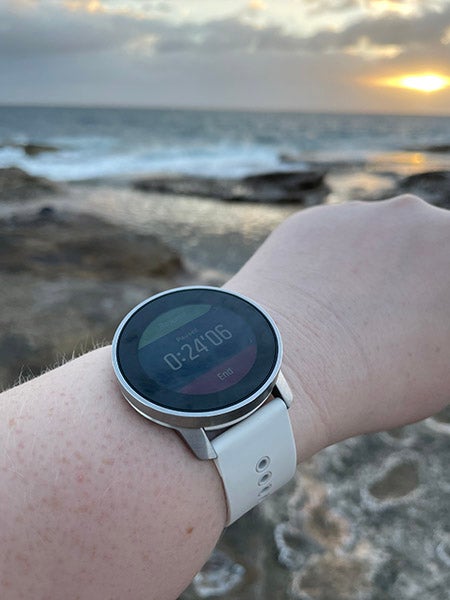 手臂上戴着Suunto 9 Peak手表，背景是海洋