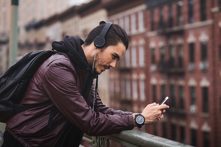 一名男子戴着耳机在外面看手机
