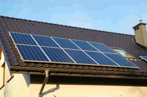 太阳能电池板坐在屋顶的底部,面对阳光