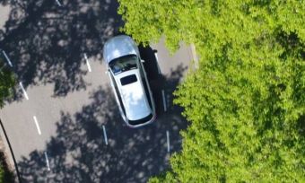电动汽车开车穿过树木鸟瞰视图