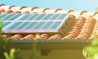 倾斜的屋顶，上面有太阳能电池板，被树木覆盖