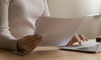 女人在电脑上比较账单。