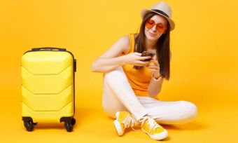 女人的手提箱和橙色装备使用电话