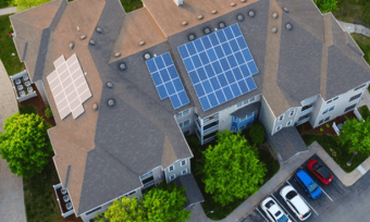 屋顶上有太阳能电池板的房子的俯视图”decoding=