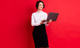 微笑的女人使用笔记本电脑和红色背景